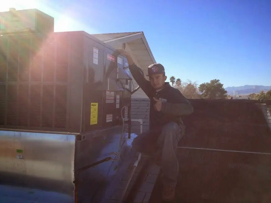 HVAC technician performing HVAC Inspection on a rooftop unit in Portage